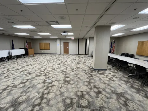 Jessie Thomas Meeting Room AB is shown in this photo. There are some tables and chairs set up and some tables are up against a wall. There is a lots of  space available in this combined meeting room AB at the Avon-Washington Township Public Library.